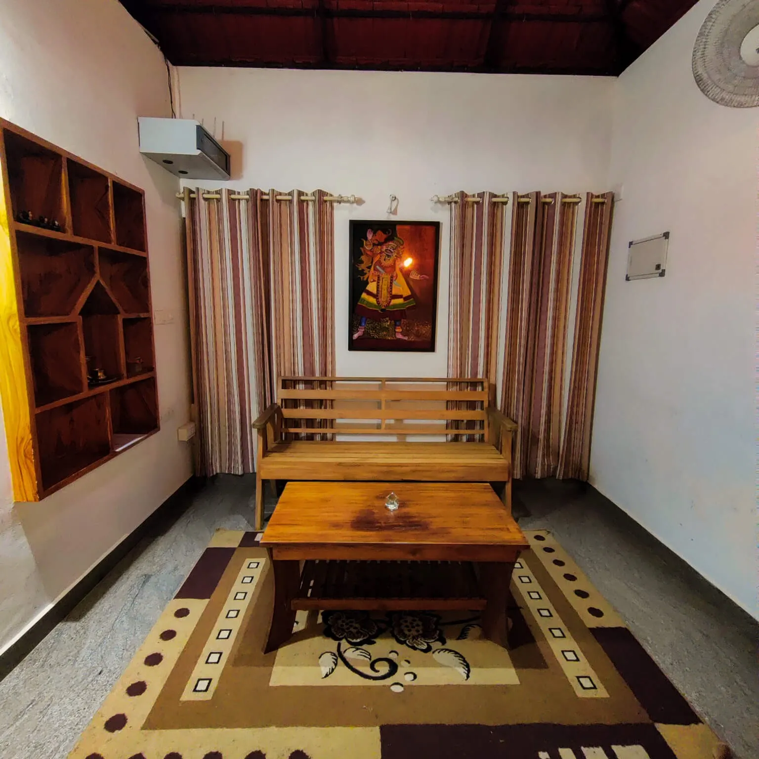 A sitting room in Agate villa, with a wooden bench and low table on a patterned rug