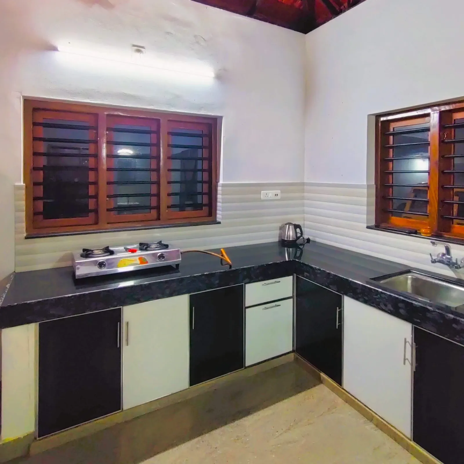 The kitchen, with an L-shaped counter, gas hob and sink below the windows
