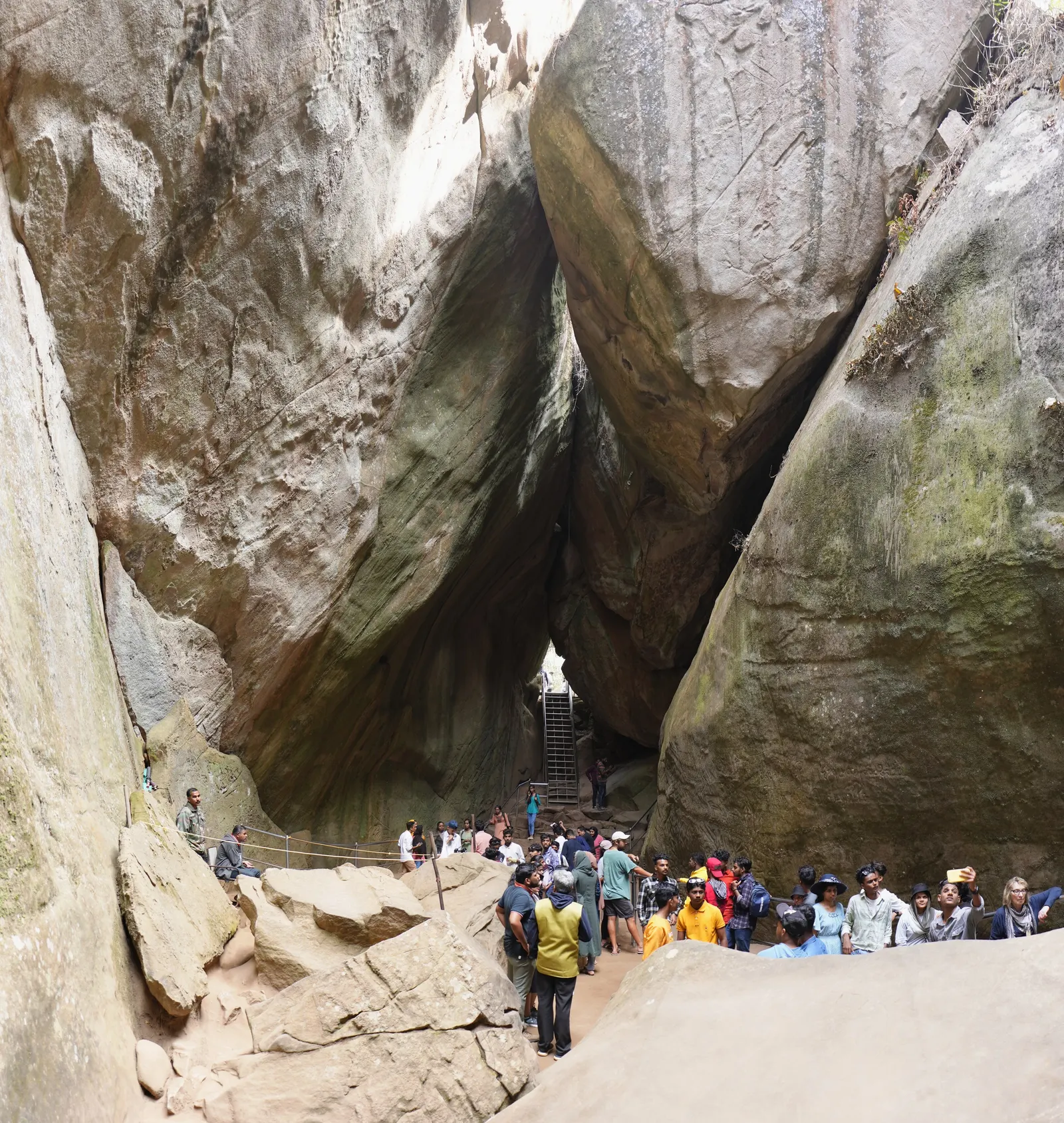Visitors gathered at the narrow cleft between the two huge rock faces that form the Edakkal caves